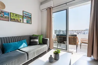 a living room with a couch and a large window at Sonic 2-Bedroom Apartment in Larnaka
