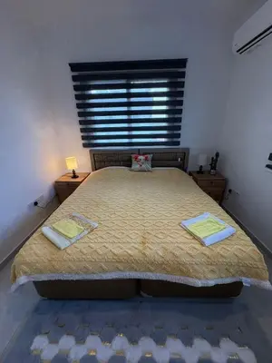 a bedroom with a large bed with a window at Lapta Yellow 1 bedroom in Limassol