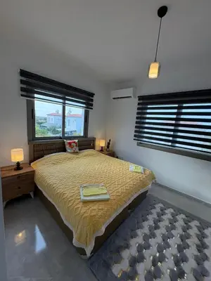a bedroom with a large bed and two windows at Lapta Yellow 1 bedroom in Limassol