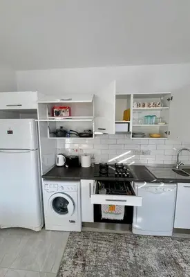 a white kitchen with a stove and a dishwasher at Lapta Yellow 1 bedroom in Limassol