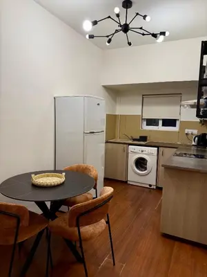 a kitchen with a table and chairs and a refrigerator at Relax Beach Apartment in Larnaka