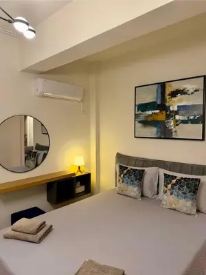 a bedroom with a large bed and a mirror at Relax Beach Apartment in Larnaka