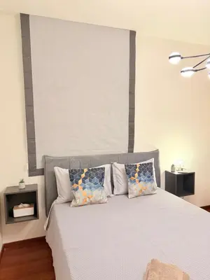 a bedroom with a white bed with pillows at Relax Beach Apartment in Larnaka