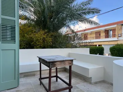 a wooden table sitting on a patio next to a building at 1947 Rescued Stone House in Nicosia