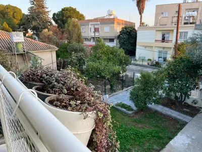 a balcony with pots of plants on a city street at 1947 Rescued Stone House in Nicosia
