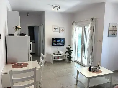 a living room with a table and a refrigerator at Cozy beachfront gem with seaview in Limassol