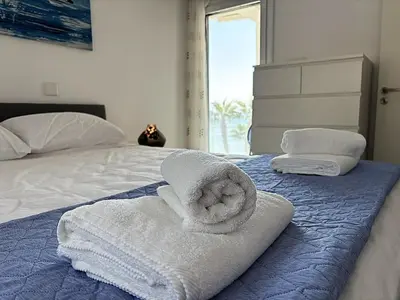 a bed with towels sitting on top of it at Cozy beachfront gem with seaview in Limassol