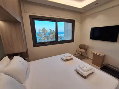 a bedroom with a large white bed with a window at Lazuli Sea View & Pool Ap 502 in Larnaka