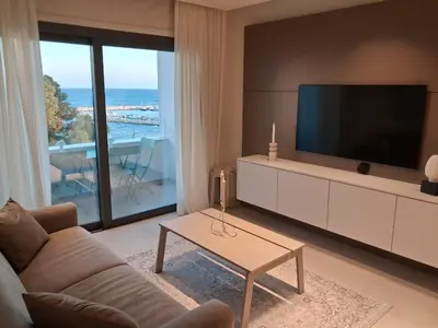 a living room with a couch and a large television at Lazuli Sea View & Pool Ap 502 in Larnaka