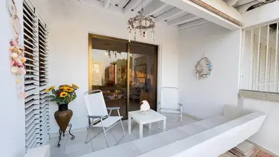 a living room with a vase of flowers and a table at SundyBeach Beachfront 2Bdr Dhekelia in Larnaka