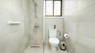 a white bathroom with a toilet and a shower at SundyBeach Beachfront 2Bdr Dhekelia in Larnaka