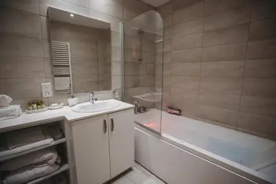 a bathroom with a tub and a sink and a bath tub at Hani Chrysomilou in Kalopanayiotis