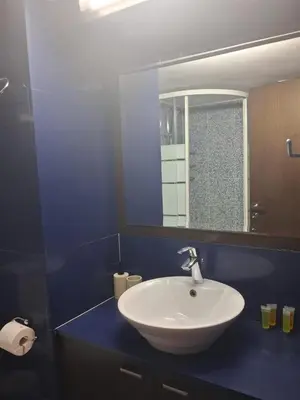 a bathroom with a white sink and a mirror at Lazuli Sea View Beachfront Studio Nr 305 in Larnaka