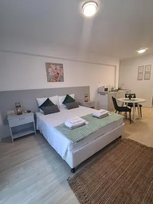 a bedroom with a bed and a table and a kitchen at Lazuli City Center Studio 161 - 100 m from the beach in Larnaka