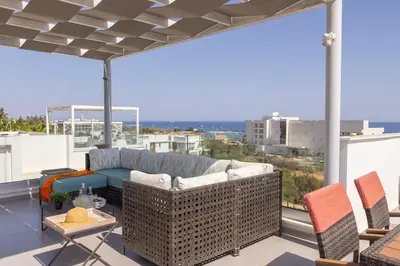 a couch on a balcony with a view of the city at Milos lifestyle H29 in Protaras