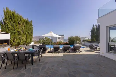 a patio with a table and chairs and a pool at Milos lifestyle H29 in Protaras