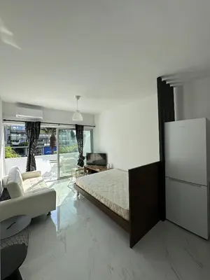 a bedroom with a bed and a couch and a tv at Seaside Studio in Limassol