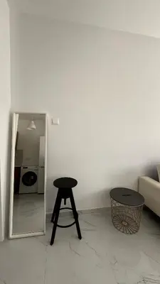 a table and stool in a room with a mirror at Seaside Studio in Limassol