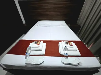 a bed with towels and water bottles on it at 5mins from the beach,10mins from LC airport Aurelia Suite in Larnaka