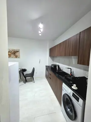 a kitchen with a washing machine and a table at 5mins from the beach,10mins from LC airport Aurelia Suite in Larnaka