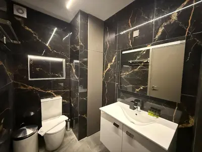 a bathroom with a white sink and a toilet at Onar Exclusive Studio Suite in Voroklini
