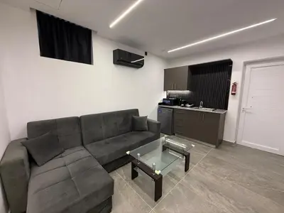 a living room with a couch and a table at Onar Exclusive Studio Suite in Voroklini