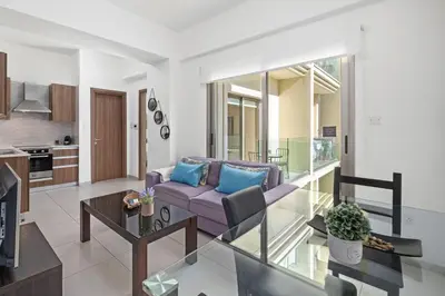 a living room with a purple couch and a table at Downtown 1 Bedroom City Apartment in Larnaka
