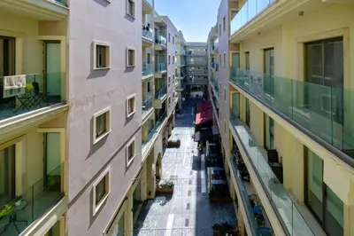 an empty corridor of an apartment building with people sitting on benches at Downtown 1 Bedroom City Apartment in Larnaka