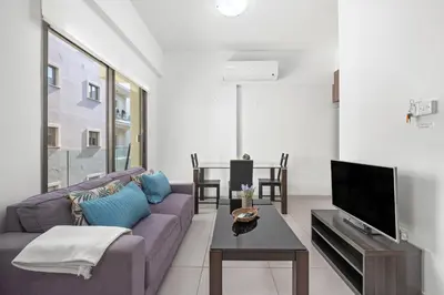 a living room with a purple couch and a tv at Downtown 1 Bedroom City Apartment in Larnaka