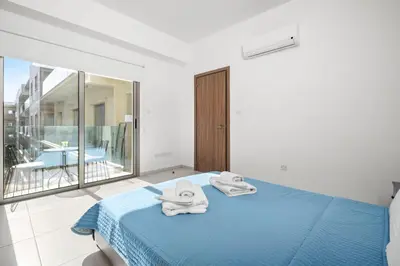 a bedroom with a blue bed with towels on it at Downtown 1 Bedroom City Apartment in Larnaka