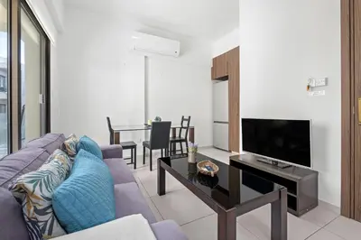 a living room with a couch and a tv at Downtown 1 Bedroom City Apartment in Larnaka