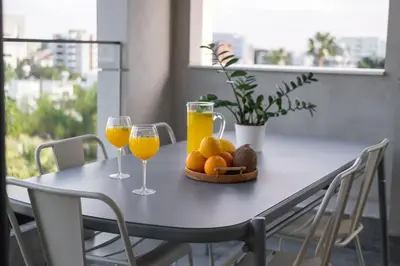 a table with two glasses of orange juice and fruit at Noir Luxury Residences by Nomads in Limassol