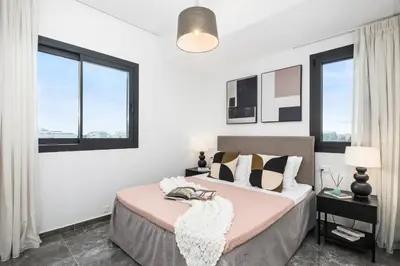 a bedroom with two beds and two windows at Noir Luxury Residences by Nomads in Limassol