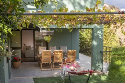 a patio with a table and chairs in a yard at Maison du Mont in Kalopanayiotis