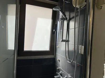a shower in a bathroom with a window at Archangelos Studio in Strovolos