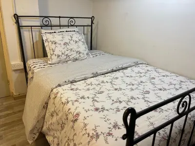 a bed with a floral comforter and a pillow at Archangelos Studio in Strovolos