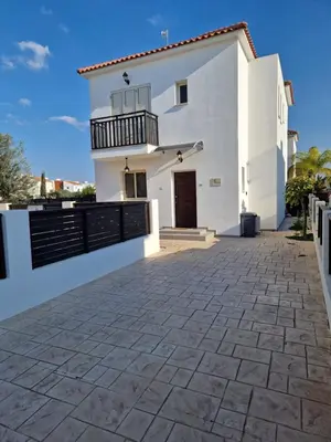 a white house with a balcony and a driveway at Sunshine Villa Kapparis in Paralimni