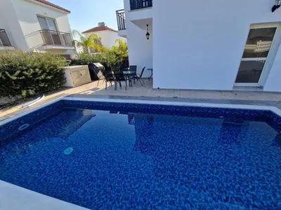 a swimming pool in front of a house at Sunshine Villa Kapparis in Paralimni