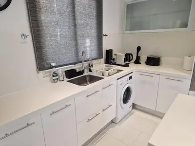 a white kitchen with a sink and a washing machine at Sunshine Villa Kapparis in Paralimni
