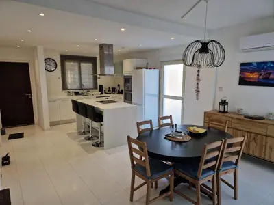a kitchen with a table and chairs and a kitchen with a refrigerator at Sunshine Villa Kapparis in Paralimni