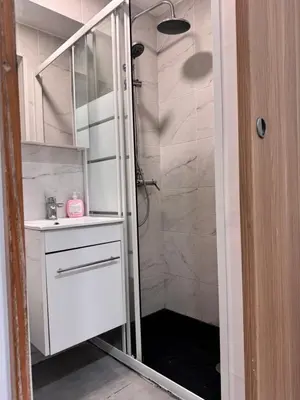 a white bathroom with a shower and a sink at Central Nicosia 1BR House in the Walled City in Nicosia