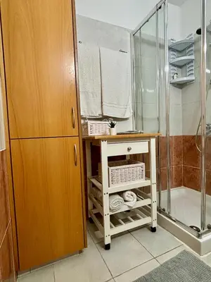 a bathroom with a shower and a table with towels at Kapparis Beach Escape in Paralimni
