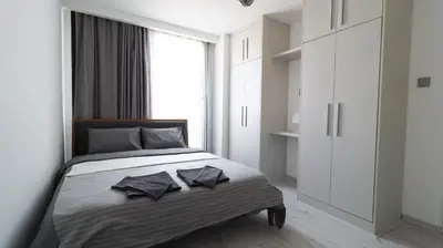 a bedroom with a bed and a large window at Girne Merkezde Geniş Teraslı Havuzlu Daire in Alsancak