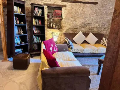 a living room with a couch with a laptop on it at Charming 3-Bedroom Cottage in Heart of Vasa Koilaniou in Vasa Kilaniou