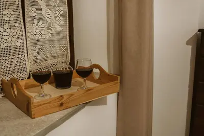 two glasses of red wine on a wooden shelf at Charming 3-Bedroom Cottage in Heart of Vasa Koilaniou in Vasa Kilaniou