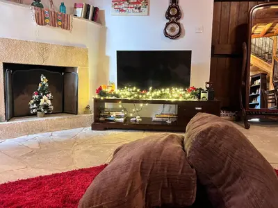 a living room with a fireplace with a television and a christmas tree at Charming 3-Bedroom Cottage in Heart of Vasa Koilaniou in Vasa Kilaniou