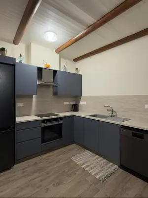 a kitchen with gray cabinets and a sink at To Petrino 2 Apartment -Authentic Comfort in the Heart of Kalopanayiotis in Kalopanayiotis