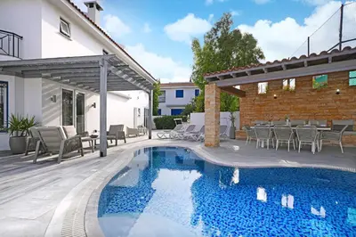 a patio with a swimming pool and a house at Villa Amy - 100m from Nisia Loumbardi Beach in Protaras