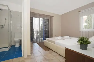 a bedroom with a large bed and a shower and a toilet at Villa Amy - 100m from Nisia Loumbardi Beach in Protaras