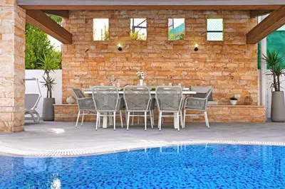a patio with a table and chairs next to a pool at Villa Amy - 100m from Nisia Loumbardi Beach in Protaras